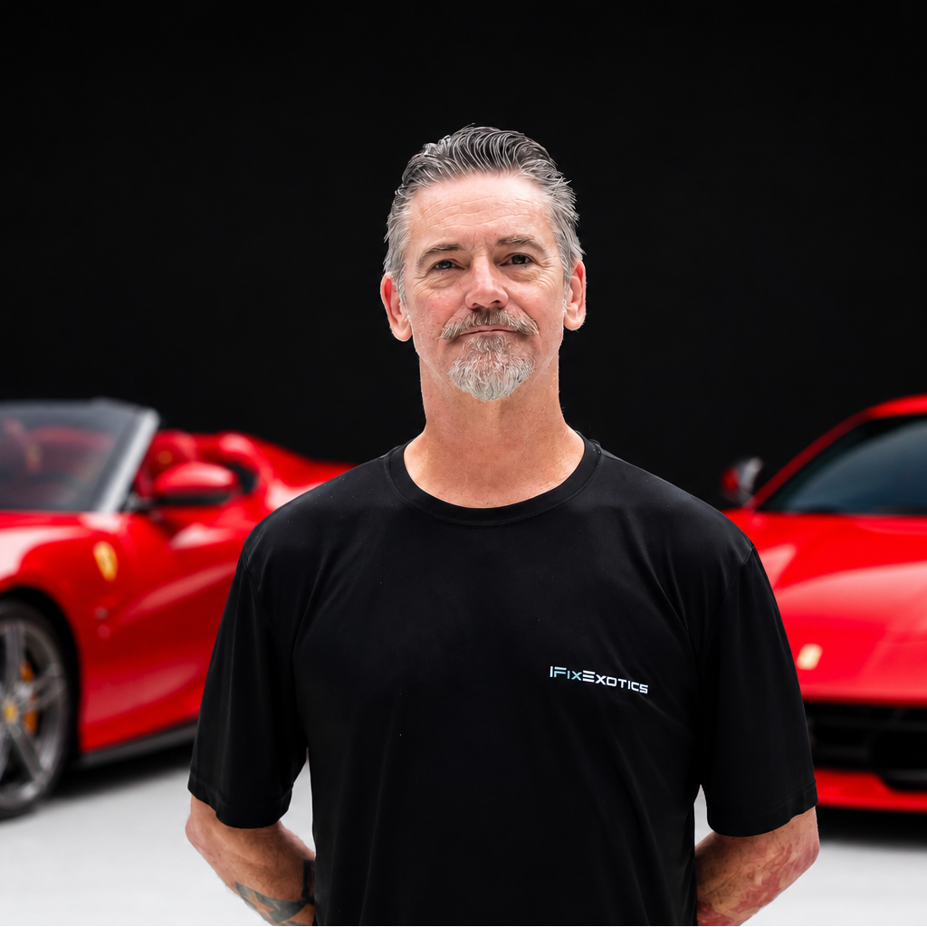 Eddypng | Txtcharlie Man with gray hair and goatee wearing a black FixExotics shirt, standing in front of red sports cars behind him.